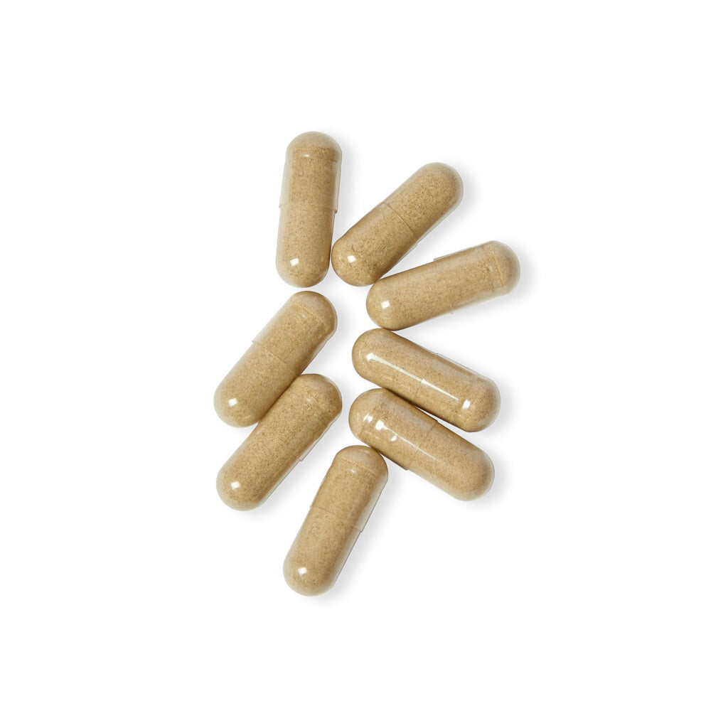 Beige capsules scattered on a white background
