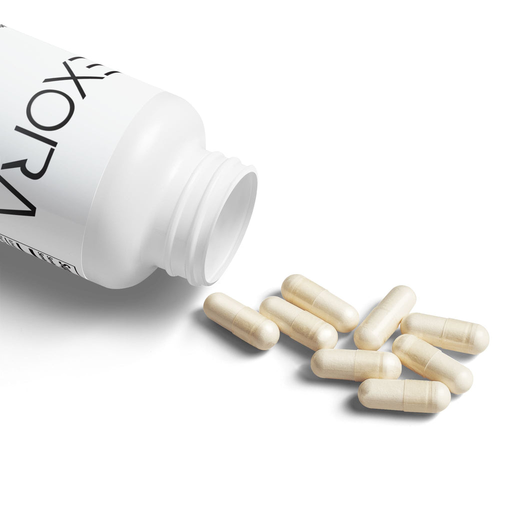White bottle labeled 'EXORA' with capsules spilling out on a white background