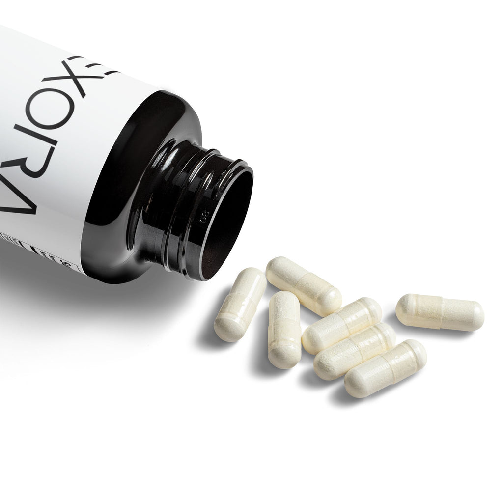 'EXORA' supplement bottle with white capsules on a white background